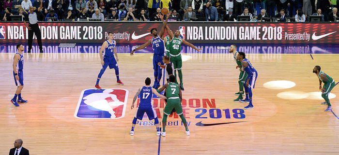 A photo of a NBA basketball court in London, 2018, featuring the new logo and various signs showing Action Condensed.