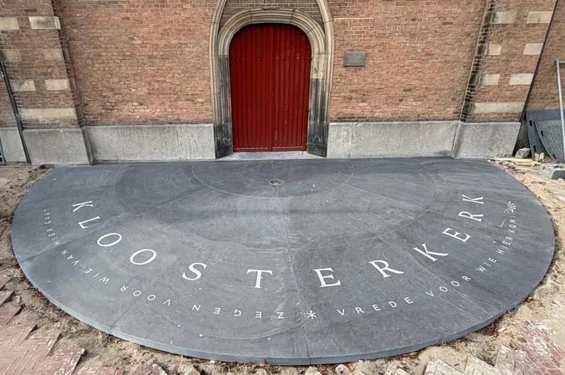 Photo of the Kloosterkerk entrace with a half circle in Belgian hardstone.